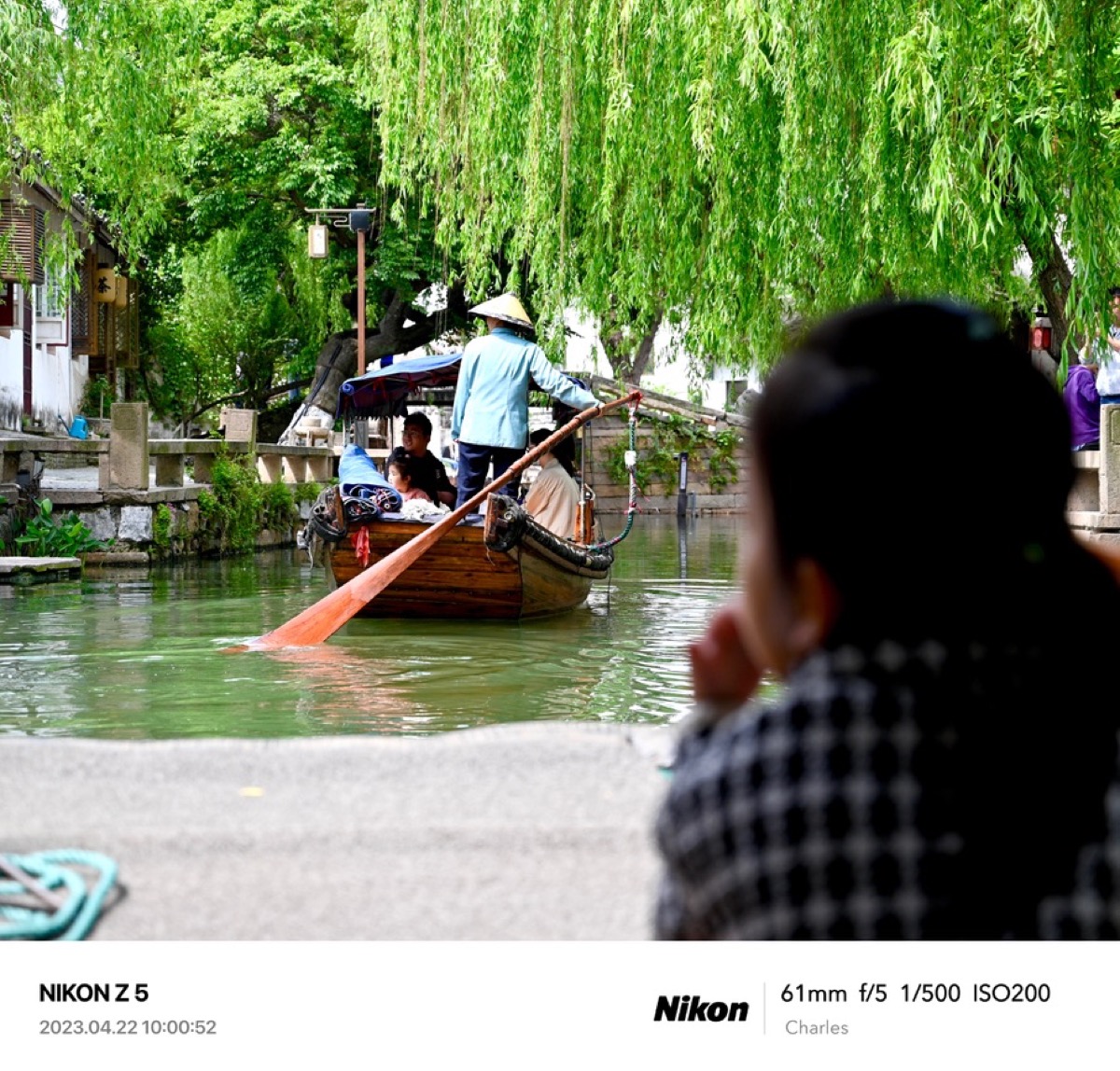 Wooden boat moving through a green canal
