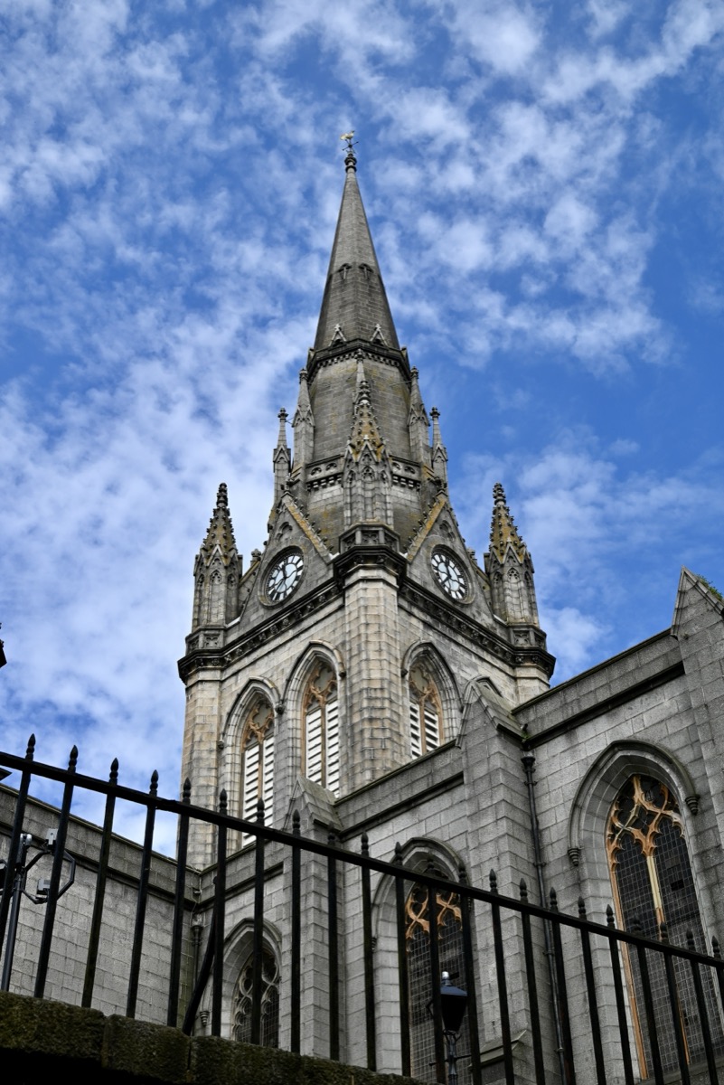 Stone church spire against a blue sky